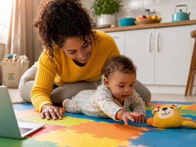 Mother helping 5-month-old baby tummy time on play mat