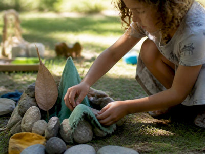 Child playing with natural loose parts outside