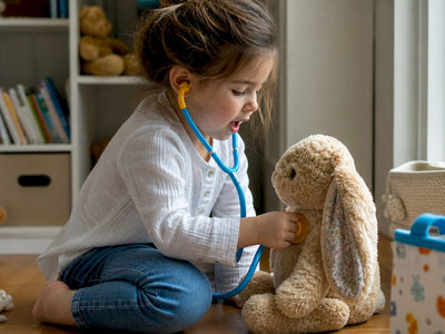 Child playing pretend doctor with stuffed bear