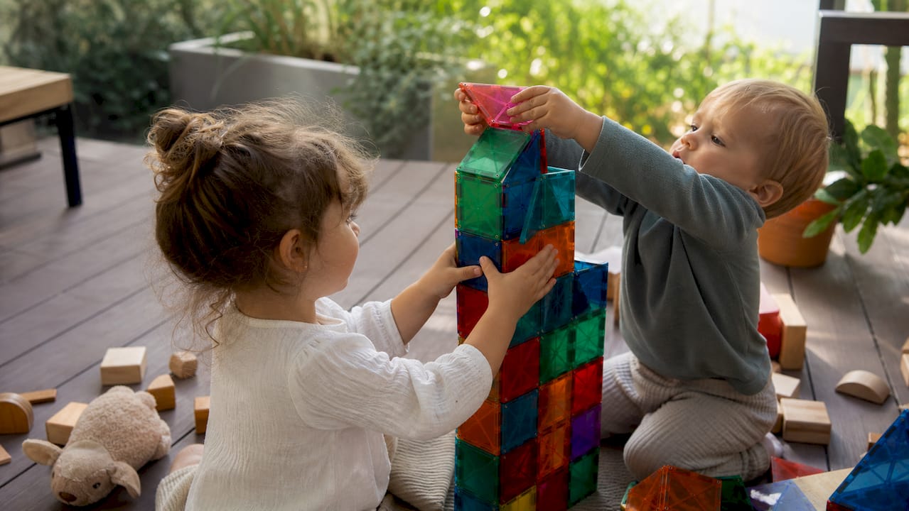 Children building stable magnet tile tower