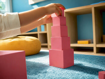 Child building a pink cube tower