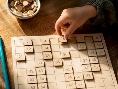 Child placing tile on hundred board