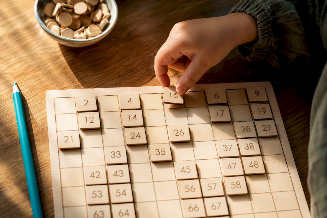 Child placing tile on hundred board