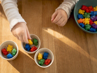 Hands arranging counting bears into equal groups