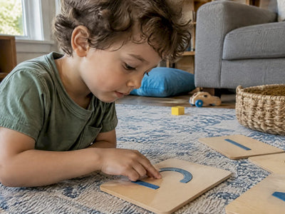 Child tracing Montessori sandpaper letters