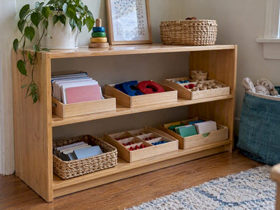 Six low-cost Montessori language trays on shelf