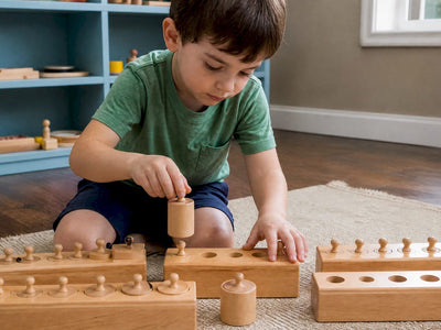 Child working with wooden knobbed cylinders