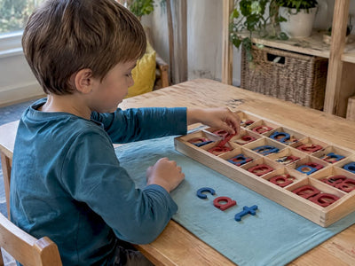 Child arranging Montessori movable alphabet letters