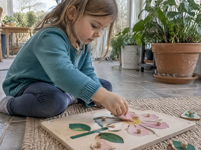 Child fitting a piece into a flower puzzle