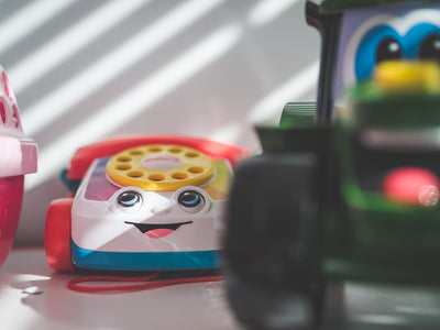 a toy phone sitting next to a toy car