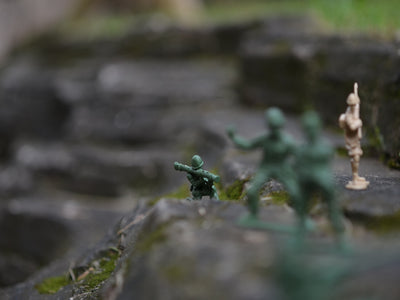 a group of toy soldiers standing on top of a rock