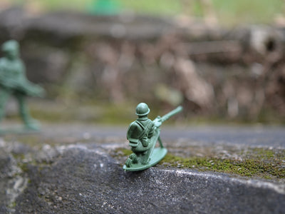 a toy soldier with a gun on a rock