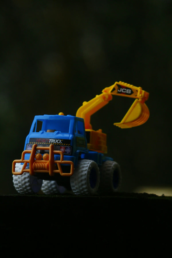 A blue toy truck with a yellow bulldozer on top of it