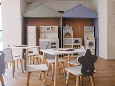 Children's play kitchen area with small tables and chairs