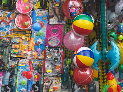 A colorful stall selling various toys and inflatable balls.