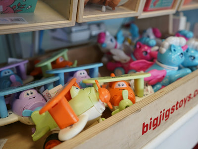 Assorted colorful toys in a wooden bin