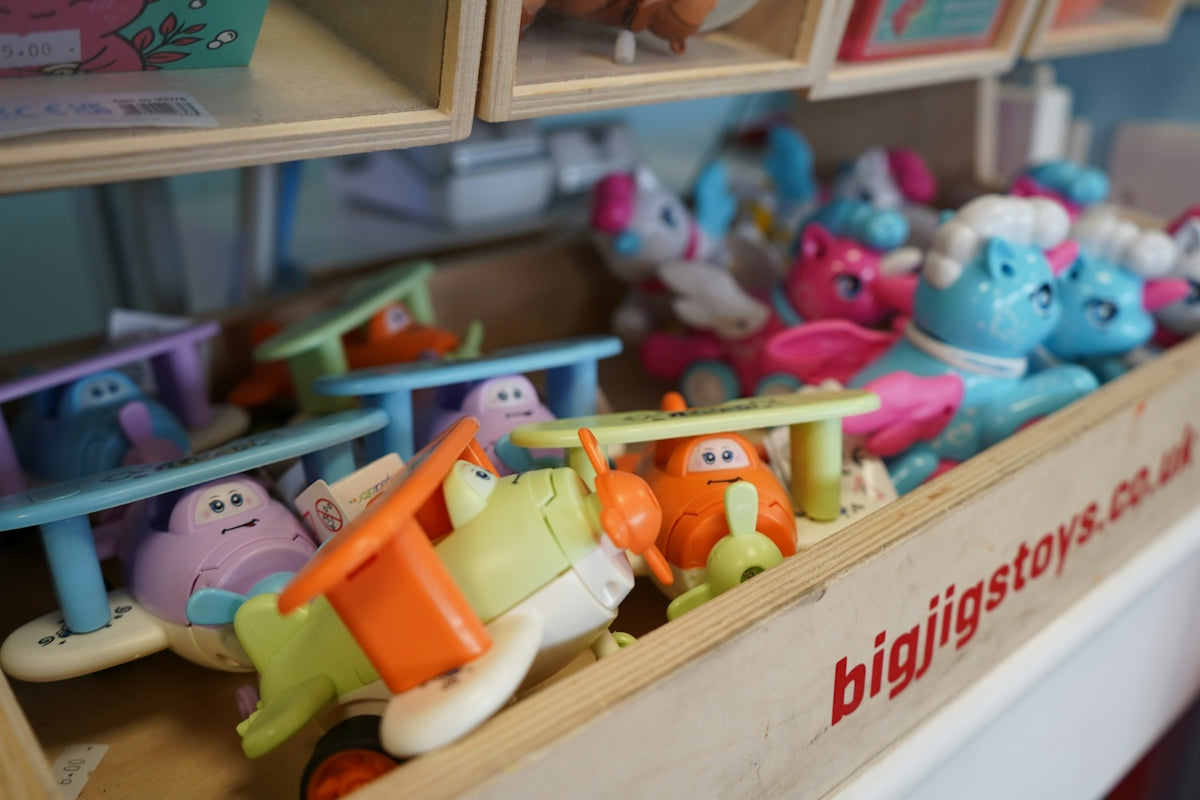 Assorted colorful toys in a wooden bin