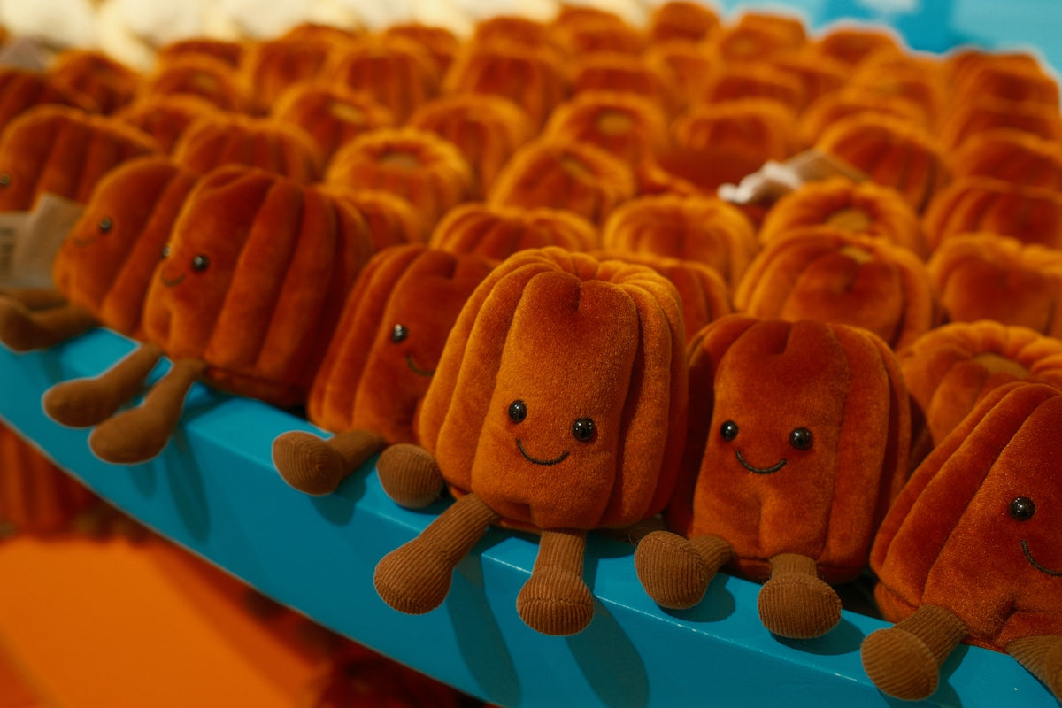 Row of cute, orange, pumpkin-shaped stuffed toys