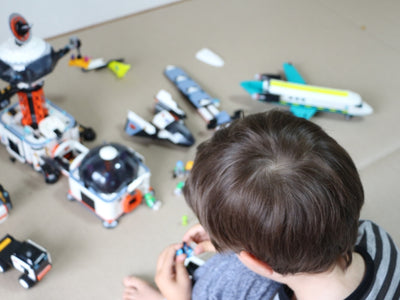 Child playing with space-themed toys on the floor