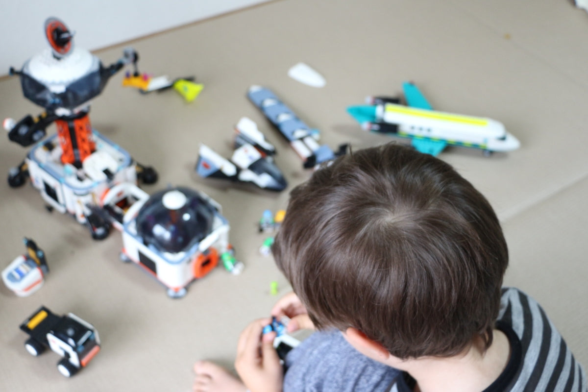 Child playing with space-themed toys on the floor